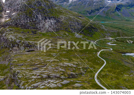 Aerial view of winding mountain road through alpine valley, Rauma Norway Aerial view of winding mountain road through alpine valley, Rauma Norway 143074003