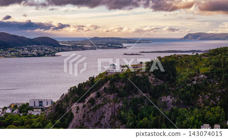 Aerial view of coastal settlement with modernist observatory on forested cliff, Alesund Norway Aerial view of coastal settlement with modernist observatory on forested cliff, Alesund Norway 143074015