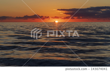 Vibrant golden sunset over the open ocean horizon with a bright sunburst and scattered clouds. Nature Vibrant golden sunset over the open ocean horizon with a bright sunburst and scattered clouds. Nature 143074041