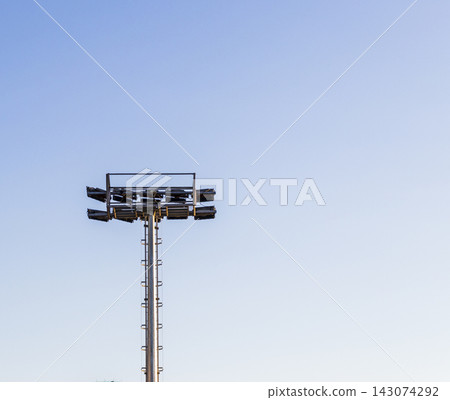 Low angle minimalist view of an industrial stadium floodlight tower against a clear sky. Concept Low angle minimalist view of an industrial stadium floodlight tower against a clear sky. Concept 143074292