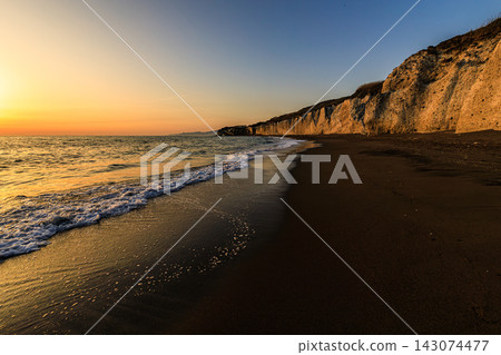 An exotic travel scene in Hokkaido: The Shirafura cliffs and quiet sandy beach illuminated by the setting sun. An exotic travel scene in Hokkaido: The Shirafura cliffs and quiet sandy beach illuminated by the setting sun. 143074477