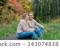 Young happy Caucasian couple in love holding hands and enjoying the moment during romantic walk on nature in the fall park. Autumn mood. Youth feelings and first love emotions concept. 143074838