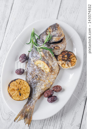 Whole roasted sea bream with lemon rosemary olives and caramelized garlic Mediterranean style Whole roasted sea bream with lemon rosemary olives and caramelized garlic Mediterranean style 143074882
