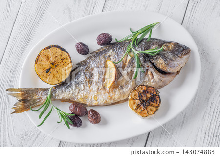 Whole roasted sea bream with lemon rosemary olives and caramelized garlic Mediterranean style Whole roasted sea bream with lemon rosemary olives and caramelized garlic Mediterranean style 143074883