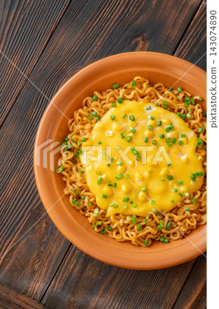 Cheesy corn ramen with scallions and wooden chopsticks on dark rustic table Cheesy corn ramen with scallions and wooden chopsticks on dark rustic table 143074890