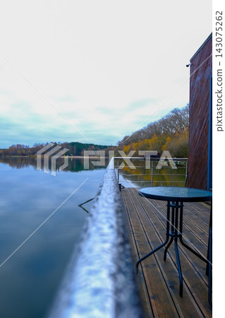 Lakeside deck and modern wood building by a calm Belarus lake Lakeside deck and modern wood building by a calm Belarus lake 143075262