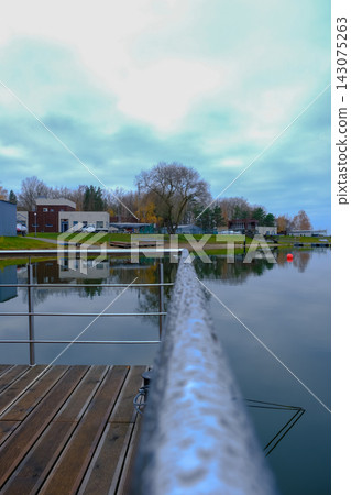 Lakeside pier and marina in Belarus with buoy and cloudy sky view Lakeside pier and marina in Belarus with buoy and cloudy sky view 143075263