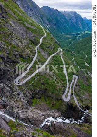 Aerial view of mountain switchback road descending steep valley, Norway Aerial view of mountain switchback road descending steep valley, Norway 143075382