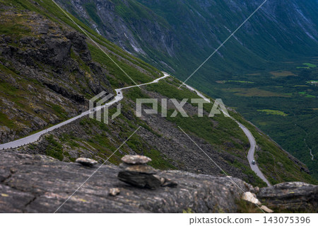 Aerial view of mountain road with hairpin turns descending steep valley, Norway Aerial view of mountain road with hairpin turns descending steep valley, Norway 143075396
