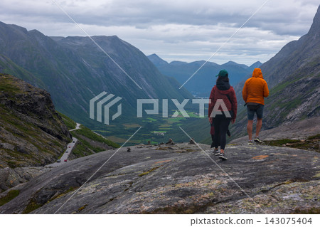 Trail runners on mountain plateau overlooking valley, Norway Trail runners on mountain plateau overlooking valley, Norway 143075404