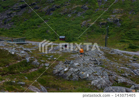 Aerial view of hikers on rocky mountain terrain with moss vegetation, Norway Aerial view of hikers on rocky mountain terrain with moss vegetation, Norway 143075405