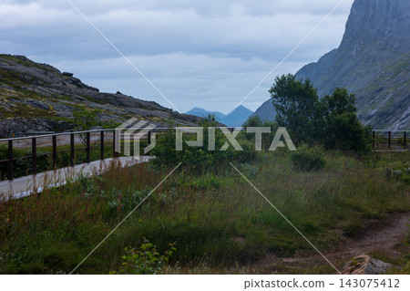 Mountain valley with wooden ranch fencing and alpine peaks, Norway Mountain valley with wooden ranch fencing and alpine peaks, Norway 143075412
