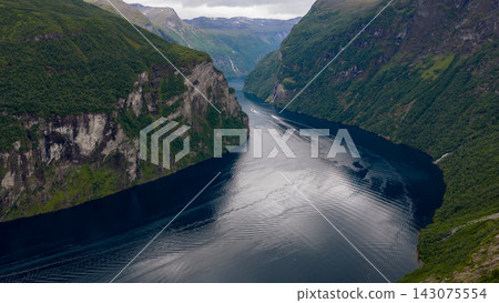 Aerial view of Geirangerfjord with steep forested cliffs and cruise vessel, Norway Aerial view of Geirangerfjord with steep forested cliffs and cruise vessel, Norway 143075554