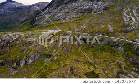 Aerial view of mountain valley with winding road and scattered buildings, Rauma Norway Aerial view of mountain valley with winding road and scattered buildings, Rauma Norway 143075577