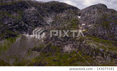 Rocky mountain valley with moss-covered slopes and patches of snow, Rauma Norway Rocky mountain valley with moss-covered slopes and patches of snow, Rauma Norway 143075581