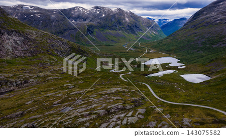 Aerial view of Rauma valley with winding road, alpine lakes and snow-capped mountains, Norway Aerial view of Rauma valley with winding road, alpine lakes and snow-capped mountains, Norway 143075582