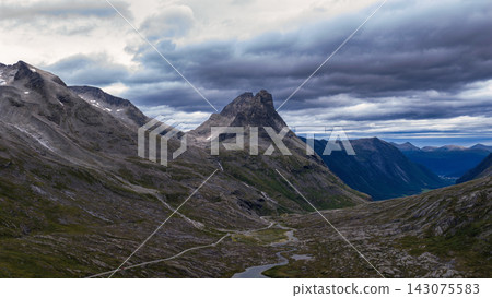 Mountain valley with peaked summit and braided stream, Rauma Norway 143075583