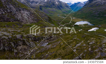 Aerial view of valley with winding road and glacial lakes, Rauma region Norway 143075584