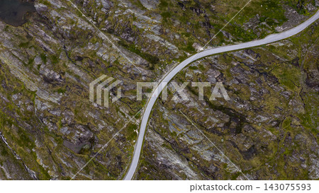 Aerial view of winding road through moss-covered rocky terrain, Rauma Norway Aerial view of winding road through moss-covered rocky terrain, Rauma Norway 143075593