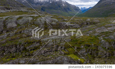Rocky alpine valley with moss-covered boulders and mountains, Rauma Norway Rocky alpine valley with moss-covered boulders and mountains, Rauma Norway 143075596
