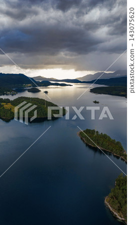Aerial view of lake with forested islands and mountains, Straumen Norway Aerial view of lake with forested islands and mountains, Straumen Norway 143075620