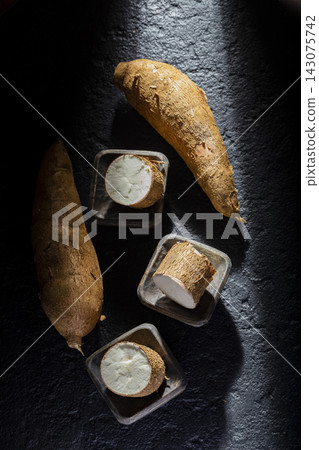 pile of cassava and cassava flour on dark background (Manihot esculenta) pile of cassava and cassava flour on dark background (Manihot esculenta) 143075742