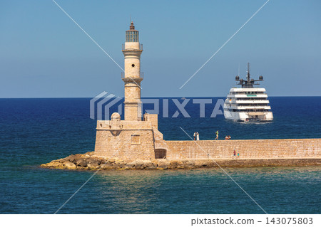 Chania Lighthouse and Luxury Yacht in Venetian Harbor, Crete, Greece Chania Lighthouse and Luxury Yacht in Venetian Harbor, Crete, Greece 143075803