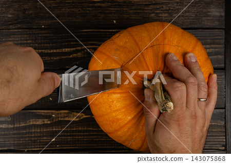 Cutting a pumpkin for Halloween decoration in October 143075868