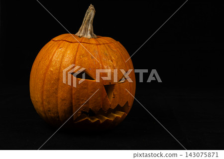 Carved pumpkin placed against a black background for Halloween festivities Carved pumpkin placed against a black background for Halloween festivities 143075871