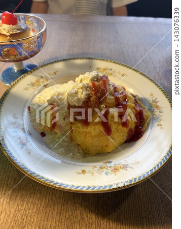 蛋包飯淋上番茄醬,盛裝放在復古西式餐盤中。 蛋包飯淋上番茄醬,盛裝放在復古西式餐盤中。 143076339