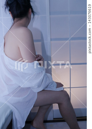 A young woman sitting at the window A young woman sitting at the window 143076619