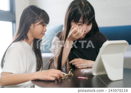 Sisters doing their makeup together Sisters doing their makeup together 143078216