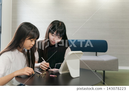 Sisters doing their makeup together Sisters doing their makeup together 143078223