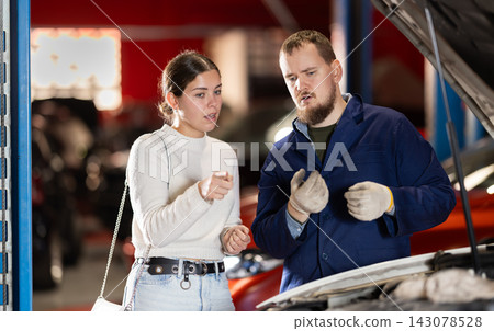 Woman Consulting Male Mechanic About Car Woman Consulting Male Mechanic About Car 143078528