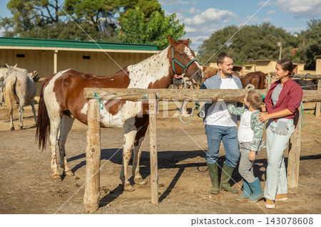 Man, woman and boy with horse at hitching post Man, woman and boy with horse at hitching post 143078608