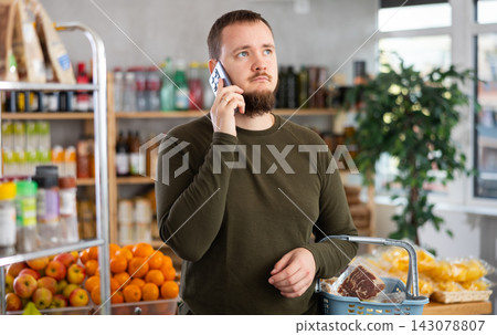 Man in the store calls on the phone. Man in the store calls on the phone. 143078807