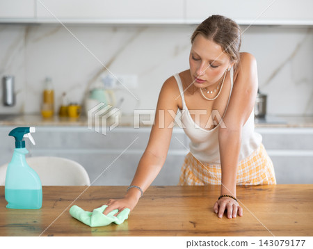 Young woman cleaning the kitchen with a rag Young woman cleaning the kitchen with a rag 143079177