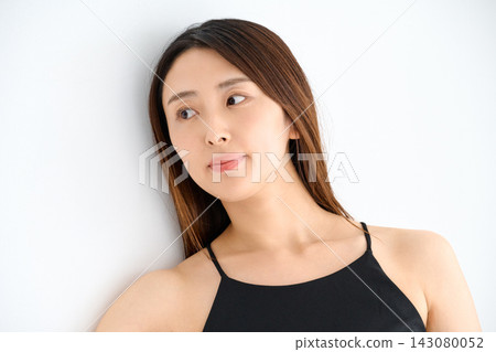 一名身穿黑色吊帶背心的女子倚靠在牆上,側身看向一旁。 一名身穿黑色吊帶背心的女子倚靠在牆上,側身看向一旁。 143080052
