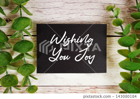 Wishing You Joy text written on paper card top view on wooden background 143080184
