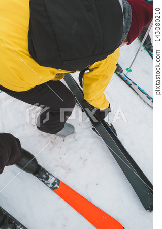 A woman carrying her skis after removing them from her skis. A woman carrying her skis after removing them from her skis. 143080210