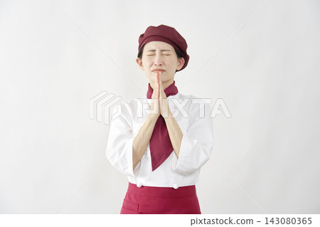 Female pastry chef/baker/cafe employee pleading against a white background. Female pastry chef/baker/cafe employee pleading against a white background. 143080365