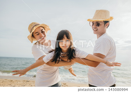 Asian family is playing together in fly action on the beach, Happy parents mother and father holding their child daughter spread arms out like airplane wings, family is enjoying their summer Asian family is playing together in fly action on the beach, Happy parents mother and father holding their child daughter spread arms out like airplane wings, family is enjoying their summer 143080994