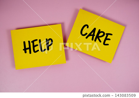 Help and Care text written on paper notes top view on pink background Help and Care text written on paper notes top view on pink background 143083509