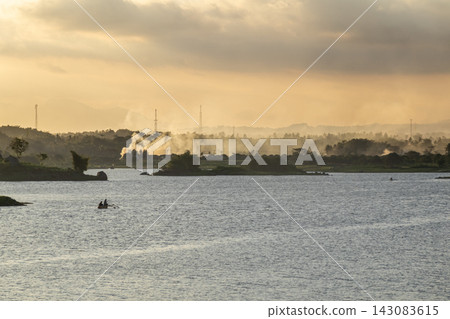 Beautiful Sunset over Lake with Small Boat Beautiful Sunset over Lake with Small Boat 143083615