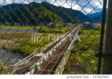 透過鐵絲網可以看到隱匿在山脈的鐵路橋和鐵軌。 143083661