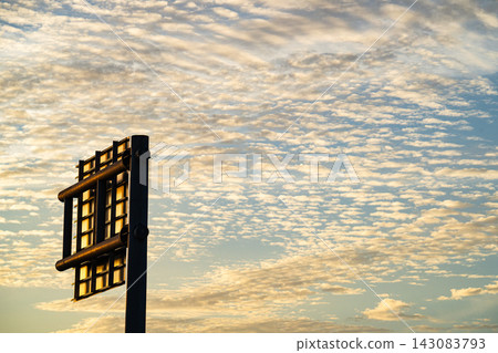 A silhouette of a road sign against a backdrop of autumn cirrus clouds and evening light. A silhouette of a road sign against a backdrop of autumn cirrus clouds and evening light. 143083793