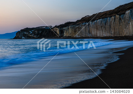 暮色中的藍色大海和輕柔拍打著海岸的白色波浪：瀧瀨海灘白芙拉的夢幻日落景象。 143084020