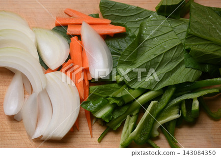 Komatsuna, carrots, and onions cut on a cutting board 143084350