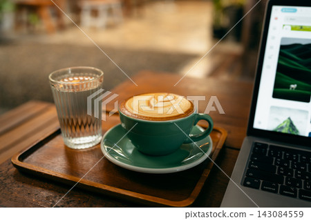 Remote work lifestyle, laptop screen showing photos with a cup of hot coffee on rustic wooden table. Remote work lifestyle, laptop screen showing photos with a cup of hot coffee on rustic wooden table. 143084559