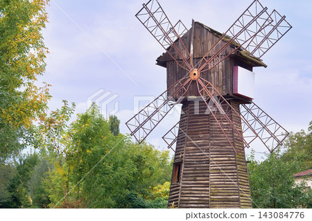 Old abandoned windmill among green trees Old abandoned windmill among green trees 143084776